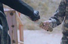 لقطة من شريط فيديو أصدرته داعش يظهر أحد المتشددين وهو يعطي سكيناً لصبي صغير. بعد ذلك بلحظات، يظهر الصبي نفسه في الفيديو وهو يذبح أحد ’المرتدين‘.