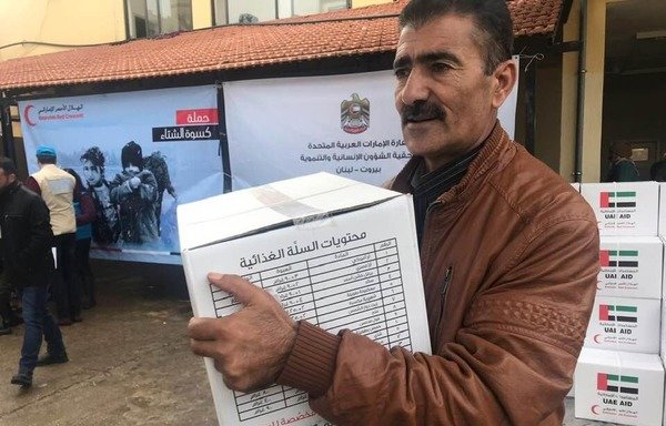 A Syrian refugee receives a food aid package as part of the UAE Response Campaign for Displaced Syrians, "Winter 2019", launched in Lebanon in early January. [Photo courtesy of the UAE embassy in Lebanon]