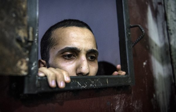 Un prisonnier soupçonné d'être affilié à l'EIIS regarde à travers l'ouverture d'une cellule dans le quartier syrien d'al-Hasakeh le 26 octobre. [Fadel Senna/AFP]