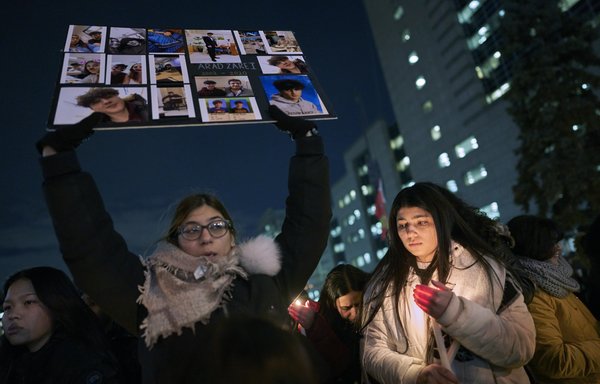 Une femme tient une pancarte pour l'une des victimes du vol 752 d'Ukrainian Airlines qui s'est écrasé en Iran, lors d'une veillée sur la Place Mel Lastman de Toronto (Ontario) le 9 janvier. [Geoff Robins/AFP]