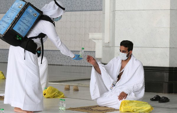 A picture taken July 29th shows a pilgrim receiving water at the Grand Mosque complex in the holy city of Mecca, at the start of the annual hajj. [STR/AFP]