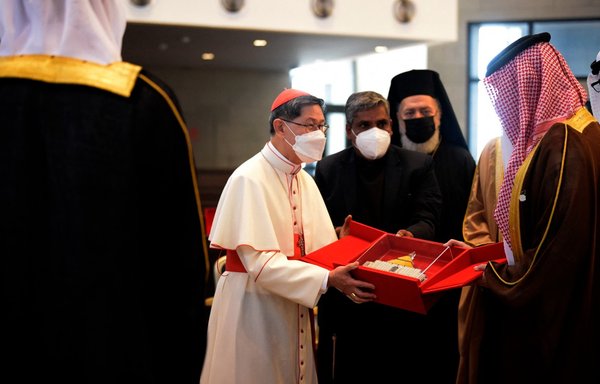 Cardinal Luis Antonio Tagle (C) gifts a replica of Our Lady of Arabia Cathedral to Sheikh Abdullah bin Hamad Al Khalifa (R) during its inauguration in Awali, south of Manama, on December 9. [Mazen Mahdi/AFP]
