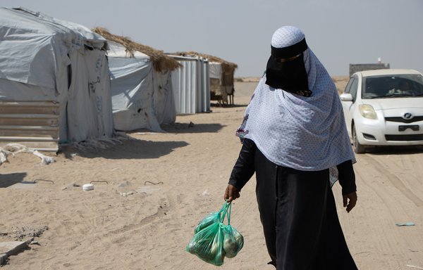زنی در یک اردوگاه آوارگان داخلی یک کیسه غذا در دست دارد. خانواده‌های ساکن اردوگاه‌ها از افزایش تورم و هزینه زندگی در یمن به مراتب آسیب بیشتری دیده‌اند. [شورای پناهندگان نروژ]