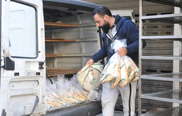 چند نفر مشغول گذاشتن نان در یک ون هستند. در بحبوحۀ بحران مداوم لبنان، حتی تأمین نان هم در خطر قرار دارد. [زیاد حاتم/المشارق]