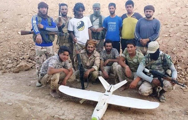 عناصر من قوات النخبة السورية التي تشكلت مؤخرا في صورة مع طائرة بدون طيار تابعة لـ ’الدولة الإسلامية في العراق والشام‘، إسقطوها في دير الزور. [حقوق الصورة للغد السوري]