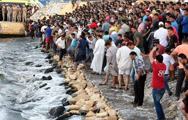Egyptians stand on the shore as they wait for the recovery of bodies during a search operation after a boat carrying migrants capsized in the Mediterranean, along the shore in the Egyptian port city of Rosetta on September 22, 2016. [Mohamed El-Shahed/AFP]
