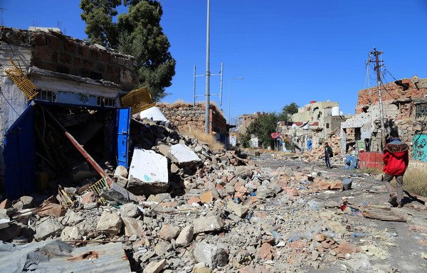 Taez residents inspect the damage on a street following clashes between Yemeni forces and the Houthis on November 22nd. [Ahmad al-Basha/AFP]