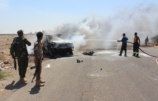 نیروهای امنیتی یمن درحال خاموش کردن یک آتش در محل انفجار یک ماشین بمب گذاری شده در محله منصوره عدن در ماه مه 2016 هستند. القاعده مظنون اجرای این حمله است. [صالح العبیدی/ خبرگزاری فرانسه]