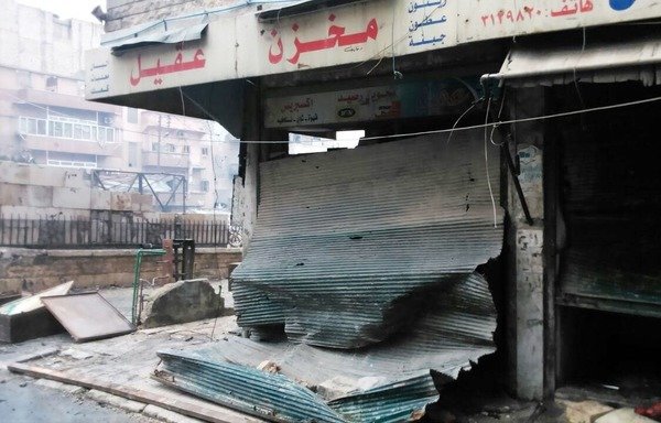 ریزش خرده شیشه های یک مغازه در منطقه شیخ سعید حلب به خیابان. برخلاف خرابی ها و آتش بس شکننده، بسیاری از ساکنین آواره مایل هستند به خانه و کسب و کار خود در شهر برگردند. [عکس با کسب اجازه از یمانا خطیب]