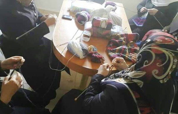 نساء سوريات يحكن ملابس الشتاء في إطار مشروع عمل صغير دعمه تجمع ضمة، وهي منظمة نسائية غير حكومية. [حقوق الصورة لمنظمة ضمة]