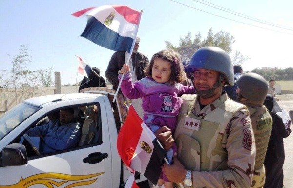 An Egyptian soldier carries a child in Sinai in a photo distributed by the Egyptian Armed Forces as part of an effort to counter 'Islamic State of Iraq and the Levant' propaganda. [Photo courtesy of the Egyptian Armed Forces]