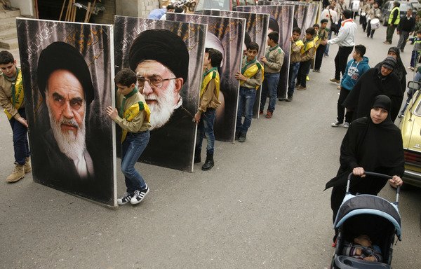 حامیان حزب الله لبنان در حال حمل عکسهای رهبران ایران روح الله خمینی و علی خامنه ای در حال راهپیمایی در شهرستان کفر حتا در لبنان در روز 18 مارس طی مراسم عزاداری یکی از رزمندگان حزب الله که در جنگ سوریه کشته شد. قطعنامه جدید شورای حقوق بشر سازمان ملل به شدت شبه نظامیان خارجی را که در کنار رژیم سوریه می جنگند، محکوم کرده است. [محمود زیات/ خبرگزاری فرانسه]