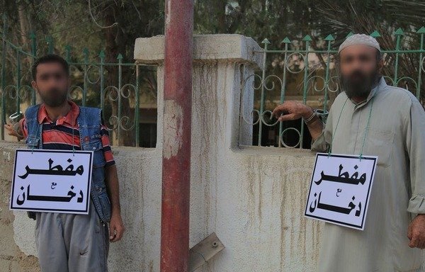 Deux hommes d'al-Raqqa sont humiliés publiquement avant d'être flagellés par « l'État islamique », car ils n'auraient pas jeûné pendant le Ramadan de 2016. [Photo fournie par Mohammed al-Abdoullah]