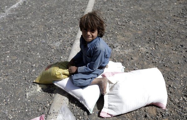 یک پسر یمنی روی کیسه کمک غذایی که توسط یک خیریه محلی در ماه مبارک رمضان در صنعا توزیع شده نشسته است. [محمد هویس/ خبرگزاری فرانسه]