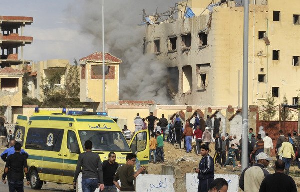 Egyptian residents and emergency personnel gather at the site of a car bomb explosion that targeted a police station in North Sinai's provincial capital of el-Arish on April 12th, 2015. [Stringer/AFP]