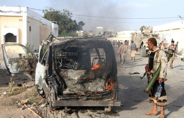 A Yemeni man looks at a burning vehicle following a reported suicide car bombing in Lahj, a bastion of al-Qaeda, on March 27th. [Saleh al-Obeidi/AFP]