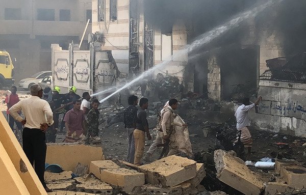 Des pompiers yéménites éteignent les flammes d'une explosion le 14 novembre près d'un poste de sécurité et revendiquée par « l'Etat islamique en Irak et en Syrie » dans la ville portuaire d'Aden, dans le sud du pays. [Nabil Hassan/AFP]