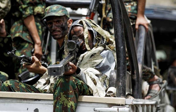 A newly-recruited Houthi fighter looks through the scope of a sniper rifle while taking part in a gathering in Sanaa, to mobilise more fighters to battlefronts on July 16th. [Mohammed Huwais/AFP]