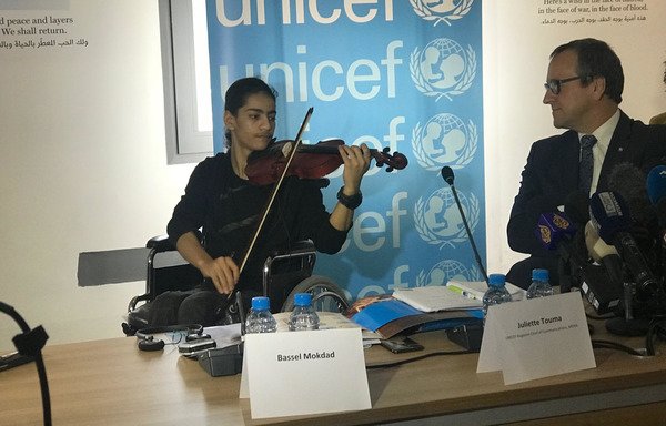 Bassel Mokdad, 17 ans, blessé par suite de la guerre en Syrie, joue du violon lors d'une conférence de presse de l'UNICEF organisée le lundi 12 mars à Beyrouth. [Nohad Topalian/Al-Mashareq]