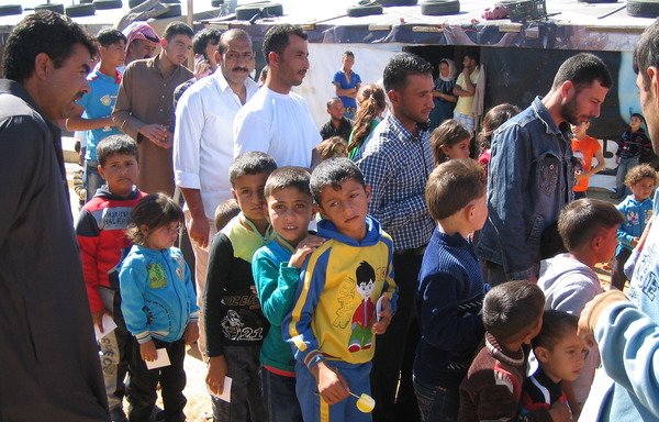 Des réfugiés syriens font la queue pour recevoir de l'aide dans la région de Zahle, dans la vallée de la Bekaa. Les réfugiés ont pesé sur les infrastructures du Liban, mais leur présence a également stimulé l'économie, ont déclaré des experts. [Junaid Salman/Al-Mashareq]