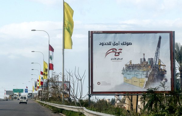 A picture taken on March 9th, along a highway in the southern Lebanese coastal city of Tyre shows electoral billboards for the upcoming parliamentary elections for the Amal movement, with flags of Hizbullah flying on street lights. [Mahmoud Zayyat/AFP]