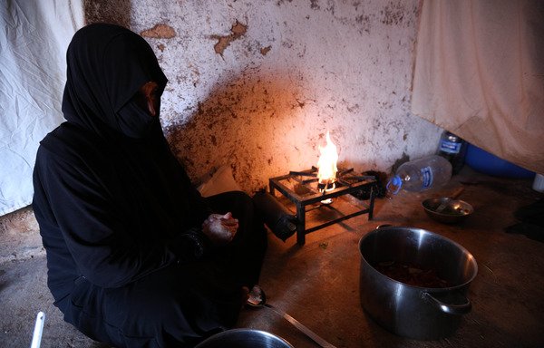 النازحة أم سامر من الغوطة الشرقية الخاضعة للمعارضة السورية، تحضر في 26 أيار/مايو الإفطار في منزل عائلتها الجديد في معرة مصرين التي تبعد سبعة كيلومترات شمال إدلب. [عمر الحج قدور/وكالة الصحافة الفرنسية]