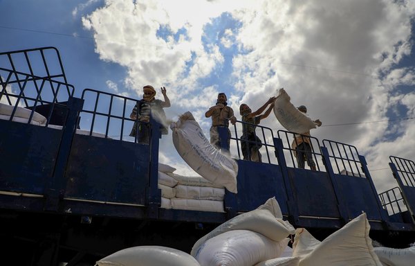 Houthis throw expired food aid from the World Food Programme off the back of a truck in Sanaa on August 27th. [Mohammed Huwais/AFP] 