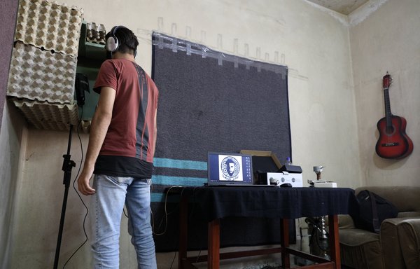 امیر المعری خواننده رپ سوری اجرایش را در اتاقش در مرآت النعمان ضبط می کند. او می گوید که رپ را «به خاطر سیاسی بودن آن» انتخاب کرد. [عمر حاج خضور/خبرگزاری فرانسه]
