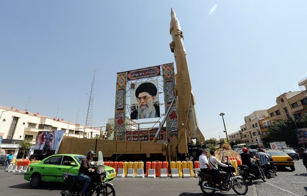 Un missile sol-sol Shahab-3 est affiché à côté du portrait du guide suprême iranien Ali Khamenei sur la place Baharestan à Téhéran le 26 septembre. [STR / AFP]