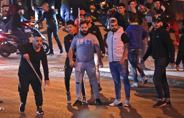 Supporters of Hizbullah and Amal clash with protestors in Beirut, on November 25th. [Anwar Amro/AFP]