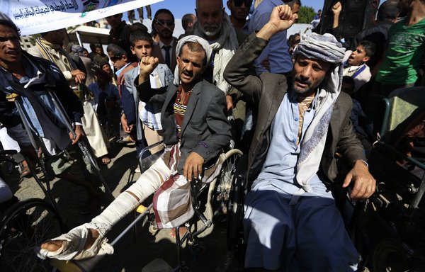 يمنيون من ذوي الإعاقات في اليمن يشاركون في احتجاج ضد الغارات الجوية قبل يوم واحد من اليوم العالمي للأشخاص ذوي الإعاقات، أمام مكتب الأمم المتحدة في صنعاء، يوم 2 كانون الأول/ديسمبر. [محمد حويس/وكالة الصحافة الفرنسية]