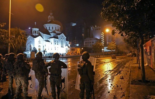 Supporters of Lebanon's Hizbullah and Amal groups and security forces clash early on December 17th in central Beirut. [Anwar Amro/AFP]
