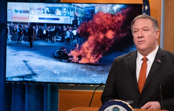 Le secrétaire d’État américain Mike Pompeo s'exprime près d'une photo de manifestations en Iran lors d'une conférence de presse au Département d’État à Washington le 26 novembre. [Saul Loeb/AFP]