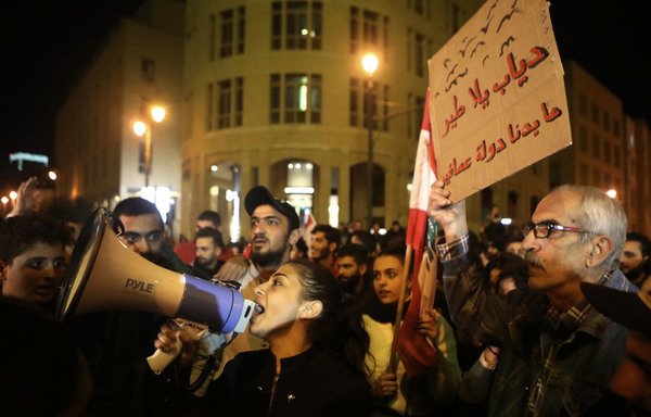 Lebanese protestors shout slogans outside the parliament to denounce the nomination of Prime Minister-designate Hassan Diab in Beirut on December 19th. [Patrick Baz/AFP]