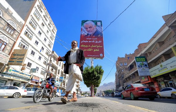 Un Yéménite marche à Sanaa le 8 janvier sous une affiche du feu commandant militaire iranien Qasem Soleimani. [Mohammed Huwais/AFP]