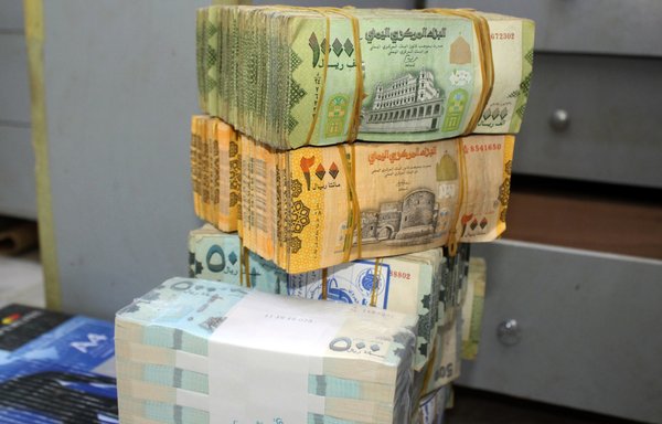 Old and new Yemeni banknotes are pictured at a money exchange office in the southern port city of Aden on January 23rd. [Saleh al-Obeidi/AFP]