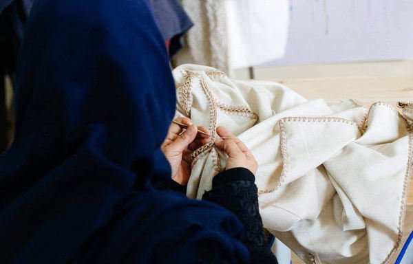 Une femme fait de la broderie dans le cadre du programme Livelihoods de Sawa for Development and Aid. [Photo fournie par Sawa]