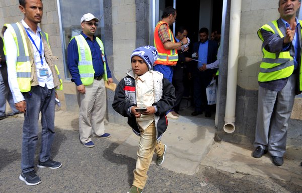 طفل يمني يسير للصعود إلى طائرة تابعة للأمم المتحدة في مطار صنعاء الدولي يوم 3 شباط/فبراير أثناء نقله إلى العاصمة الأردنية عمان لتلقي العلاج الطبي هناك. [محمد حويس/وكالة الصحافة الفرنسية]