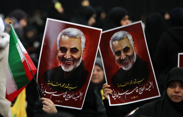 Hizbullah supporters hold posters of IRGC-QF commander Qassem Soleimani as Hizbullah leader Hassan Nasrallah delivers a speech on a screen in Beirut's southern suburbs on January 5th. [Anwar Amro/AFP]