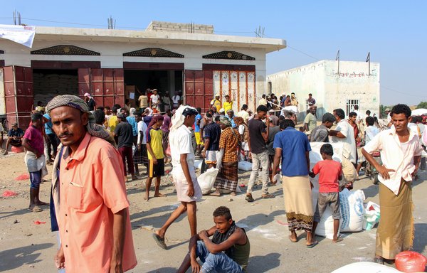 Displaced Yemenis receive humanitarian aid, donated by the World Food Programme in co-operation with the Danish Refugee Council, in the northern province of Hajjah on December 30th. [Essa Ahmed/AFP]