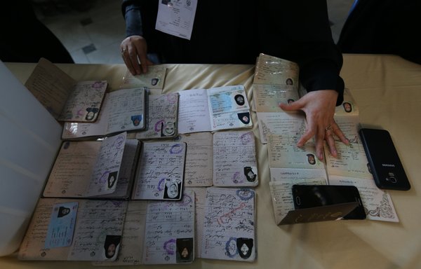 Un employé du bureau de vote vérifie les identités avant que les électeurs iraniens puissent voter lors d'une élection législative dans un bureau de vote de Téhéran, le 21 février. [Atta Kenare/AFP]