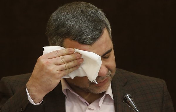Le vice-ministre de la Santé iranien Iraj Harirchi s'essuie le visage lors d'une conférence de presse à Téhéran, le 24 février. Le jour suivant, il a confirmé avoir été testé positif au coronavirus. [Mehdi Bolourian/FARS NEWS/AFP]