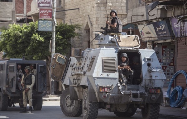 در این عکس که روز ۲۶ ژوئیه ۲۰۱۸ گرفته شده است، یک مامور پلیس مصر دیده می شود که در خیابانی در العریش، پایتخت استانی شمال شبه جزیره سینا به حالت آماده باش ایستاده است. [خالد دسوکی/ خبرگزاری فرانسه]