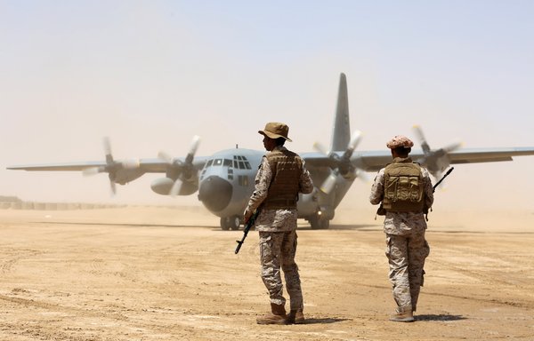 Des soldats saoudiens montent la garde avant le déchargement de l'aide humanitaire depuis un avion-cargo de l'armée de l'air saoudienne sur un aérodrome de la province de Marib au Yémen, le 12 mars 2018. La coalition arabe dirigée par l'Arabie Saoudite soutient la tentative du Yémen de reprendre certaines parties de la province aux Houthis. [Abdoullah al-Qadry/AFP]
