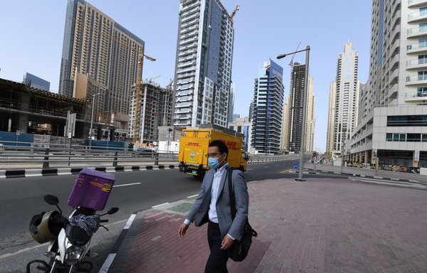 رجل يضع قناعا واقيا يسير في أحد شوارع دبي يوم 16 أذار/مارس. [كريم صاحب/وكالة الصحافة الفرنسية]