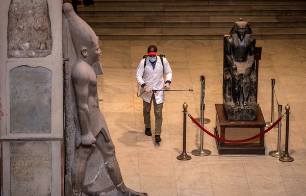 Un ouvrier désinfecte la salle des momies royales du Musée égyptien du Caire, le 23 mars, pendant la pandémie de coronavirus. [Khaled Desouki/AFP]