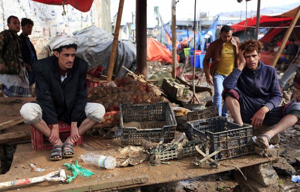 فروشندگان یمنی در حال تماشای غرفه های خسارت دیده از سیلاب پس از بارانهای شدید در صنعا در ۱۴ آوریل. [محمد هوویس/ خبرگزاری فرانسه]