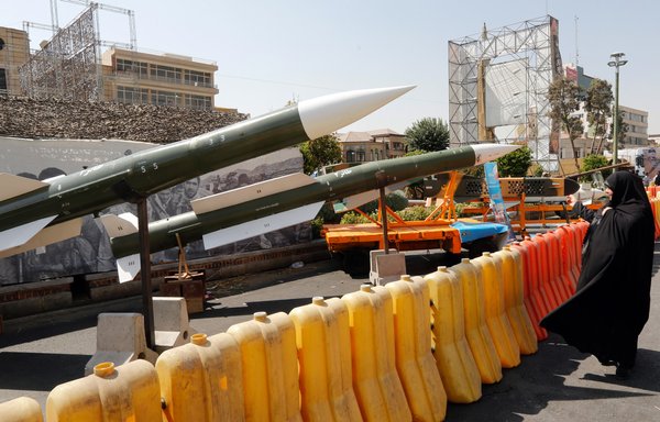 Une femme iranienne regarde les missiles Taer-2 lors d'une exhibition dans la rue par l'armée iranienne et le CGRI pendant la 'Semaine de la Défense' à la Place Baharestan à Téhéran, le 26 septembre 2019. [STRINGER/AFP]