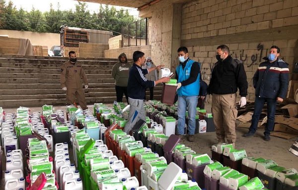UNHCR personnel distributing sanitisation and cleaning materials to Syrian refugees in Lebanon. [UNHCR]