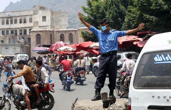 A Yemeni policeman wearing a protective face mask stands at a street market in Yemen's Taez city, on June 1st amid the novel coronavirus pandemic crisis. [Ahmed al-Basha/AFP]